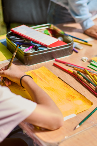 pencil crayons and drawing strewn on a table